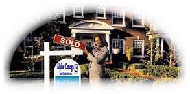 Woman in front of house for sale holding SOLD sign